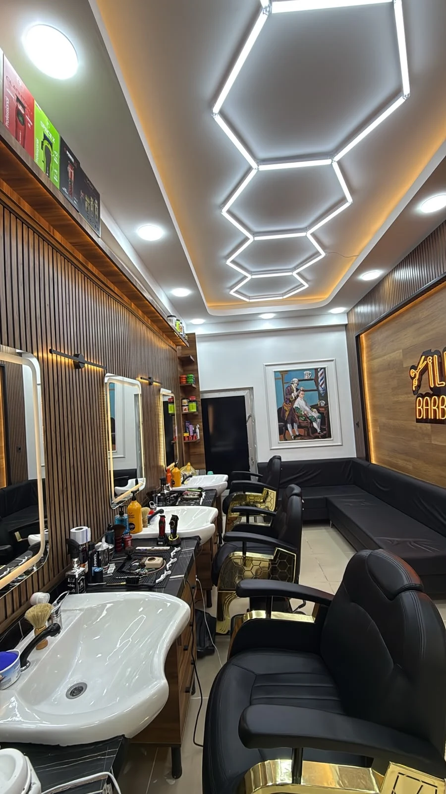 İlhan Barber Shop'un siyah ve altın detaylı berber koltukları, aynaları ve ahşap iç mekânı