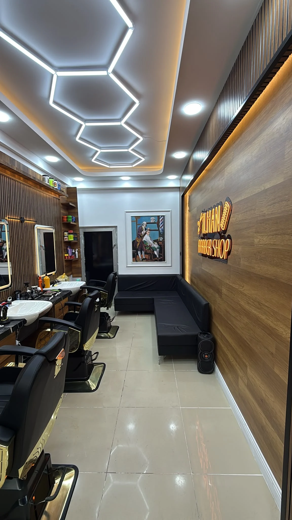 Salonun İlhan Barber Shop tabelalı ahşap duvarı ve bekleme alanı